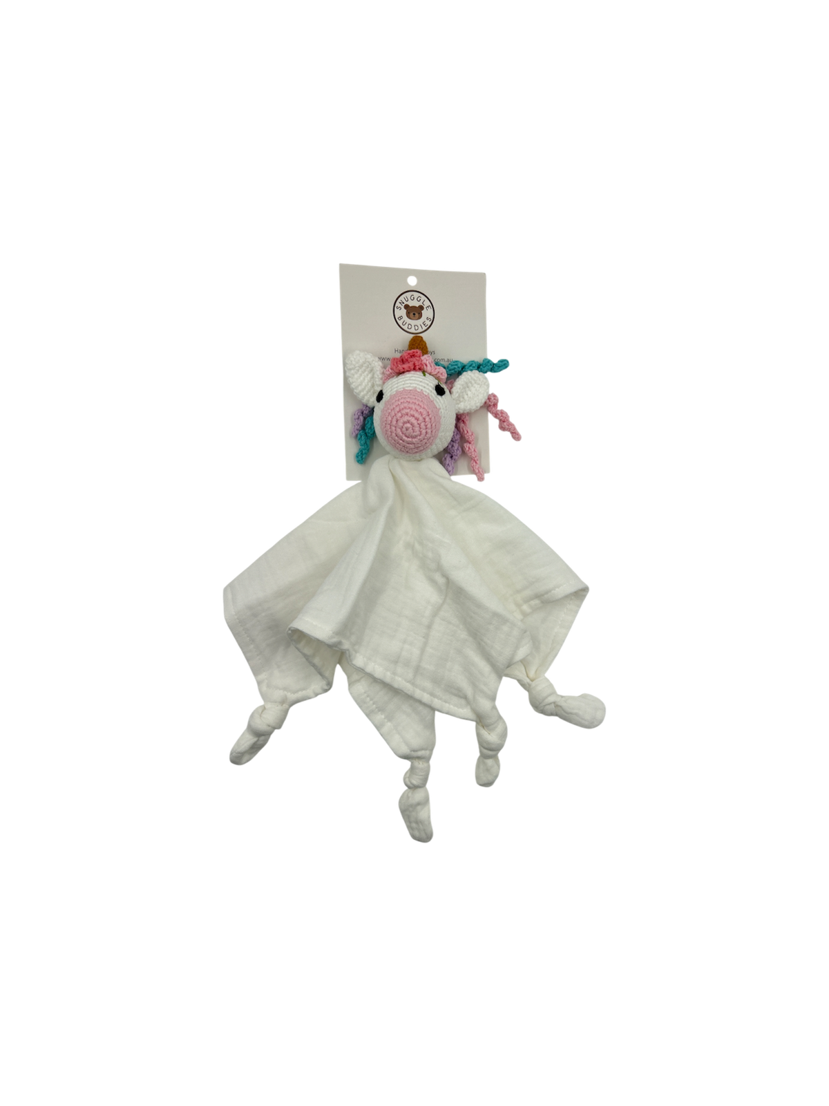 A white muslin comforter blanket featuring a crocheted unicorn head with a pink spiral nose, rainbow mane, and small pink and blue horns, attached to a white paper header card.